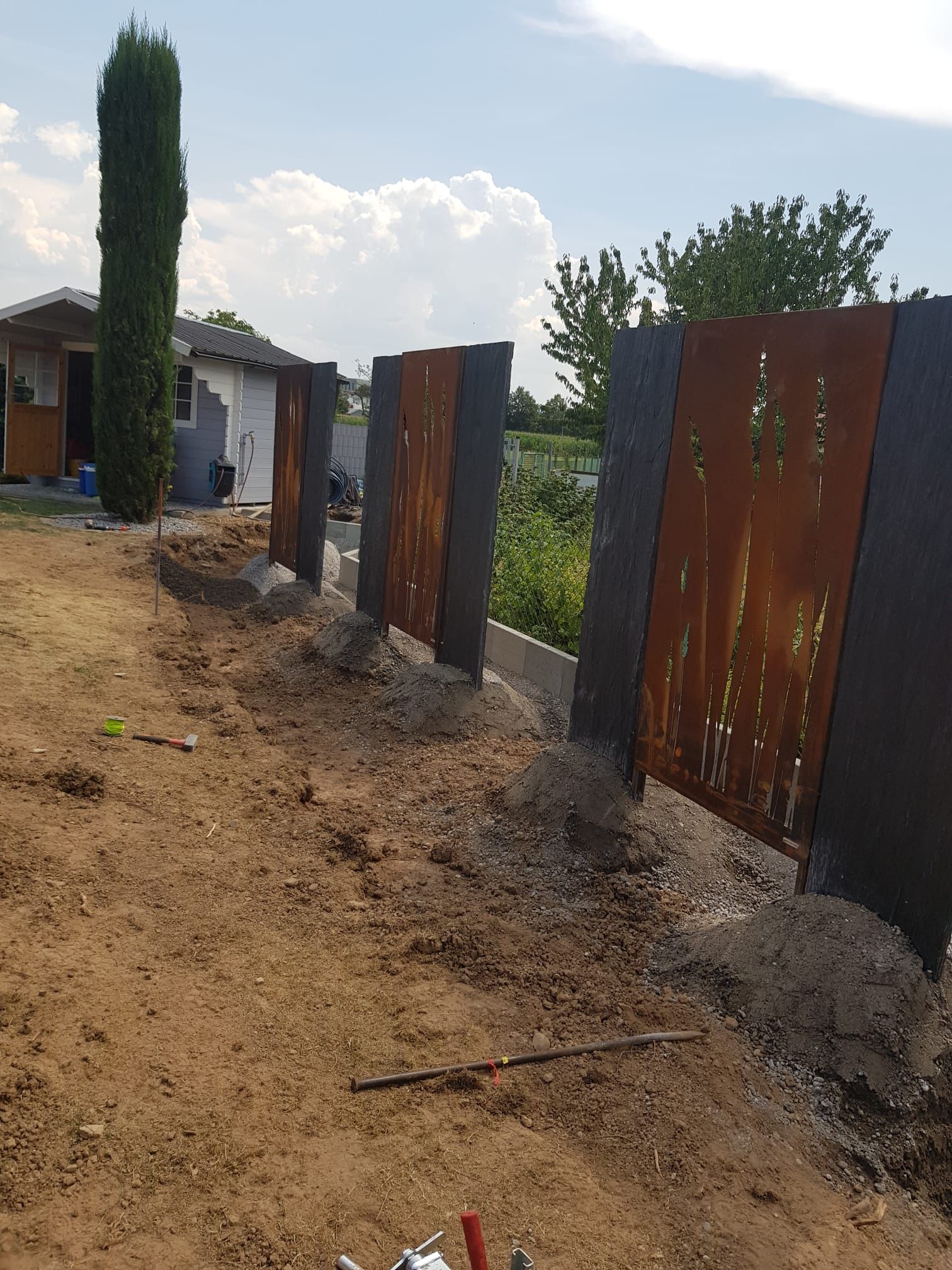 Schiefer Stele mit Betonsockel gesetzt Edelrost Platten eingerahmt.